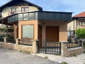 a house with a fence in front of it at Apartman Palazzo in Bosanska Krupa