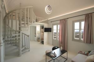 a living room with a spiral staircase and a couch at Airy Suites Santorini in Oia