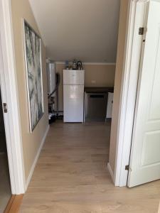 a hallway with a kitchen and a refrigerator at Bøtø strand ferielejlighed 7 in Marielyst +8 photos