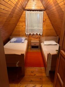 een kleine kamer met twee bedden en een raam bij Bungalows Dormire in Žabljak +30 foto's