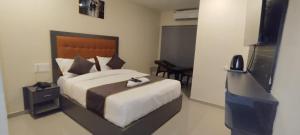 ein Schlafzimmer mit einem großen Bett und einem Fernseher in der Unterkunft hotel coolriver inn in Visakhapatnam