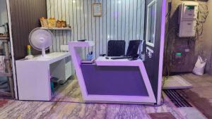 ein rosa Schreibtisch mit einem Computer in einem Zimmer in der Unterkunft hotel coolriver inn in Visakhapatnam