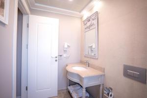 a bathroom with a sink and a mirror at Eritrina Alacati in Alacati