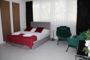 a bedroom with a bed and two green chairs at Résidence Appartment Gebenstorf in Gebenstorf