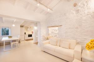 a white living room with a white couch and a table at Calma Bianca in Pythagoreio