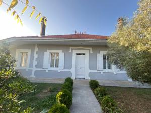a small white house with a white door at Maison climatisée 8 personnes lege cap ferret in Lège-Cap-Ferret