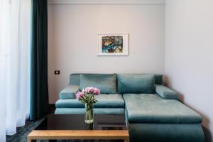 a living room with a couch and a vase of flowers at d'Eric Mamaia Nord in Mamaia Sat/Năvodari +21 photos