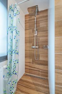 a bathroom with a shower with a wooden wall at Haus unter Gerlitzen in Bodensdorf +34 photos