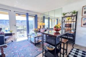 a living room with a table with a bowl of fruit on it at Dunes with Design in Hilton Head Island