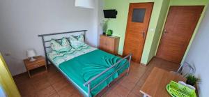 a bedroom with a bed with a green comforter at Willa Miruna w Grzybowie in Grzybowo +13 photos