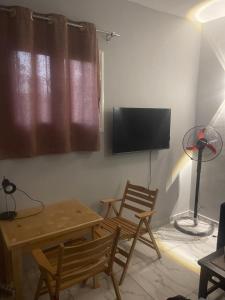 a living room with two chairs and a table and a tv at Doody Cozy chalet in Dahab