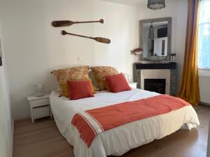 a bedroom with a bed with red and orange pillows at Maison climatisée 8 personnes lege cap ferret in Lège-Cap-Ferret