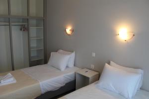 a bedroom with two beds with white pillows at Stefania rooms in Ligia