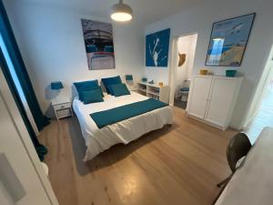a bedroom with a large bed with blue pillows at Maison climatisée 8 personnes lege cap ferret in Lège-Cap-Ferret +36 photos