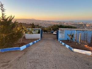 a dirt road with blue and white barriers at Camping Gourogo in Nador