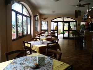 a dining room with tables and chairs and windows at Il Vapore in Oggebbio
