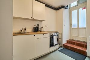 a kitchen with white cabinets and a sink and a window at Ruhiges zentrales Maisonette-Loft in Berlin in Berlin +16 photos