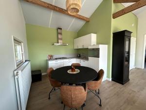a kitchen with a table and chairs in a room at Boszicht in Haskerhorne