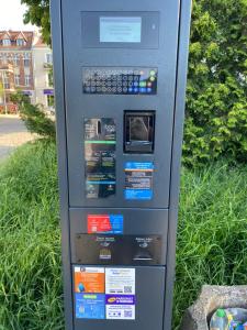 a parking meter sitting in the grass next to a street at Apartament Centrum in Malbork