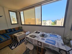 a room with a table and chairs and a couch at Sayda Appart Hotel in Chebba