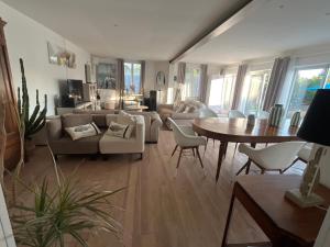 a living room with a couch and a table at Maison climatisée 8 personnes lege cap ferret in Lège-Cap-Ferret