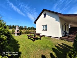 a white house with a picnic table and a bench at Paloma in Kołczewo