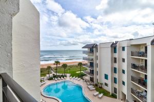 desde el balcón de un edificio con vistas a la piscina y a la playa en Sunny Ormond Beach SOB Condo Pool No Drive Beach, en Ormond Beach