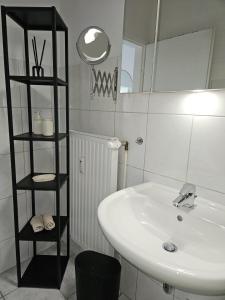 a bathroom with a white sink and a mirror at Appartment am Yachthafen in Bremerhaven