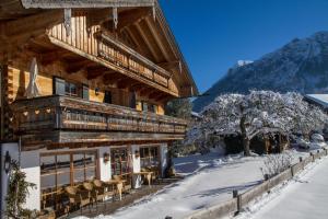 a log building with a balcony on a snowy street at Gästehaus Hirschbichler - Chiemgau Karte in Inzell