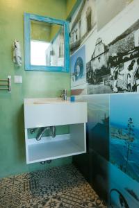 a bathroom with a sink and a mirror at Casas da villa - Apartments in Ericeira