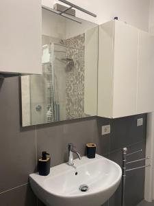 a bathroom with a white sink and a shower at NUOVO E CENTRALISSIMO in Civitanova Marche +4 photos