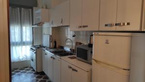 a large kitchen with white cabinets and appliances at Dolce Sosta Casa Vacanza in Comacchio