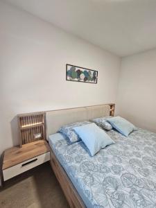 a bedroom with a bed with blue pillows at Apartma VINT in Ajdovščina