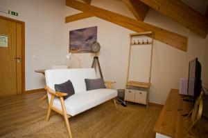 a living room with a white couch and a tv at Guest House 10 de Agosto in Figueira da Foz