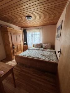 a bedroom with a large bed with a wooden ceiling at Casa Buchenweg in Schotten