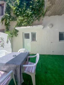 una mesa y sillas en un césped frente a una casa en Secret Garden Mostar, en Mostar 23 fotos más