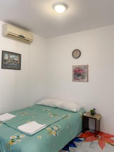 Un dormitorio con una cama y un reloj en la pared. en Secret Garden Mostar, en Mostar