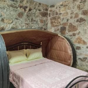 a bed in a room with a stone wall at D. Maria São Pedro de Balsemão in Lamego