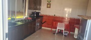 a kitchen with a stove and a table in it at شقة للكراء اليومي خصوصيتك اولويتنا مرحبا in Nador