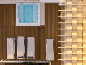 a row of white chairs on a wall with a window at Elaia's Villas Hot Tub & Seaview in Parga