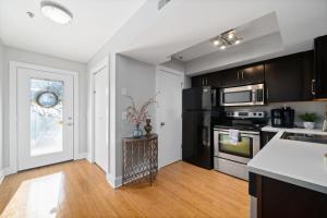 Una cocina con gabinetes negros y una encimera blanca. en The Lofts of Downtown - 540 N 2nd St - Unit 203 - Charming 2-Bedroom in the Heart of Clarksville TN, en Clarksville