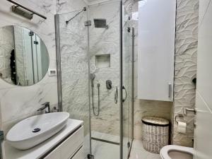 a bathroom with a shower and a sink and a toilet at The New Grey in Sarajevo +14 photos