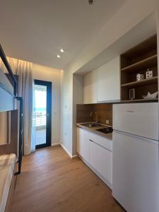 a kitchen with white cabinets and a white refrigerator at Mare Beach Apartments in Stavros
