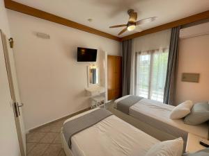 a hotel room with two beds and a window at Adult Only - Hotel Suzanna in Achladies