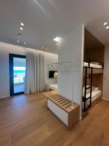 a room with bunk beds and a room with wooden floors at Mare Beach Apartments in Stavros
