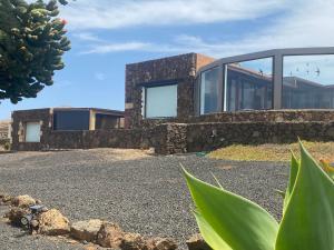 a house on a hill with a stone wall at Casa Estela in Villaverde