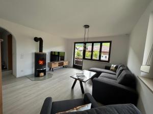 a living room with a couch and a fireplace at Allgäu Moments Oberstaufen in Oberstaufen