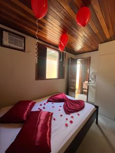 Schlafzimmer mit roten Ballons an der Decke in der Unterkunft Loft Refúgio in Angra dos Reis