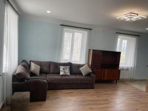 a living room with a couch and a flat screen tv at Rest home in Chʼkalovka