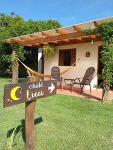 a sign in the grass in front of a house at Chalés Bons Ventos in São Bento do Sapucaí